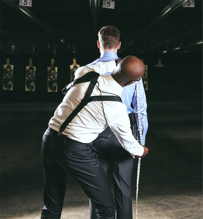 Man being measured for tactical suit in gun range