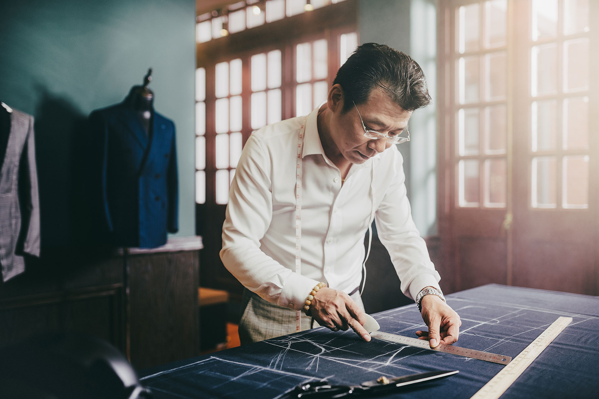 Grayman and Company tailor cutting fabric in atelier